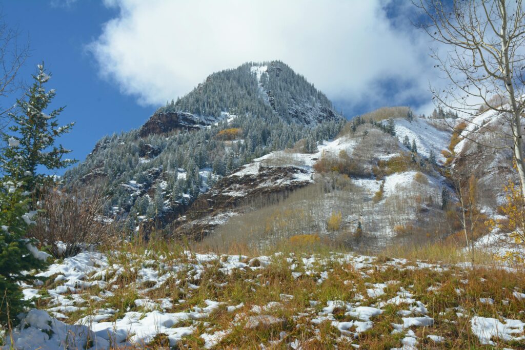 Scenic view of snow-dusted mountains in Aspen, Colorado with autumn foliage.