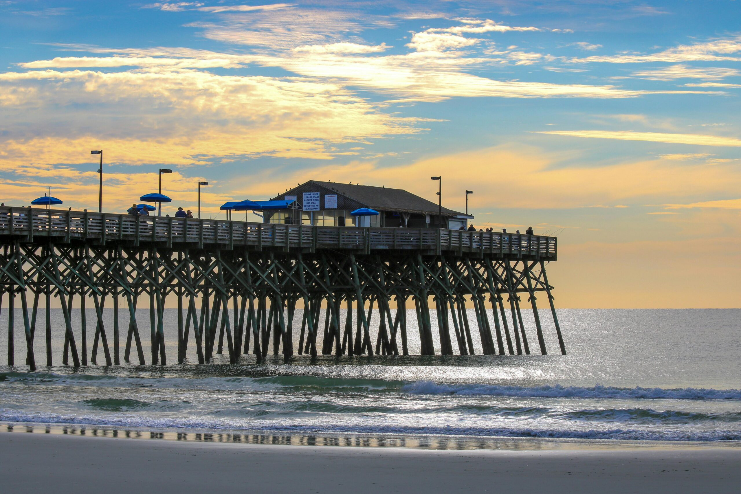 Peaceful sunset view of Garden City Pier extending into the Atlantic Ocean, capturing a tranquil coastal scene.