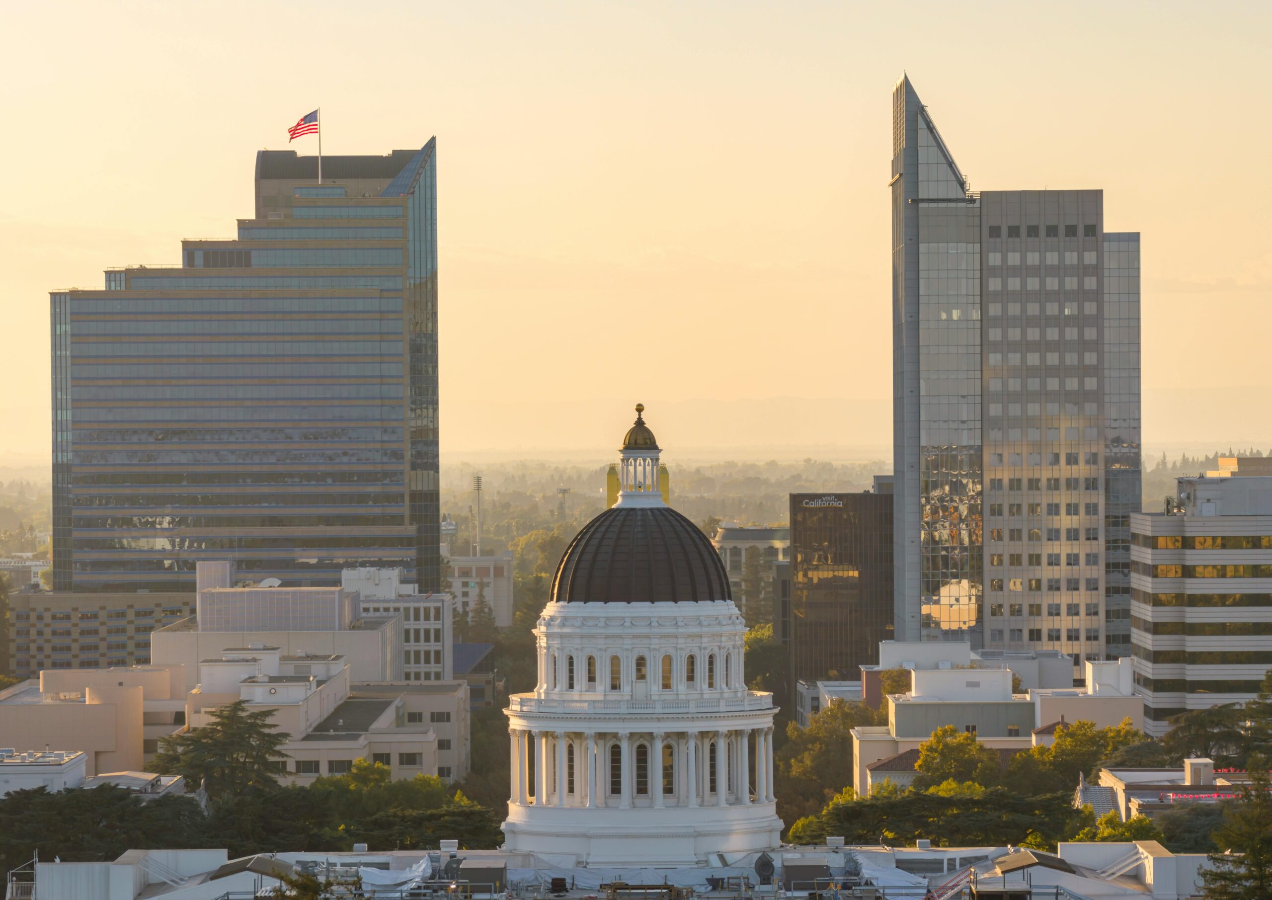 Aerial view of Sacramento skyline with the iconic California State Capitol building at sunset.