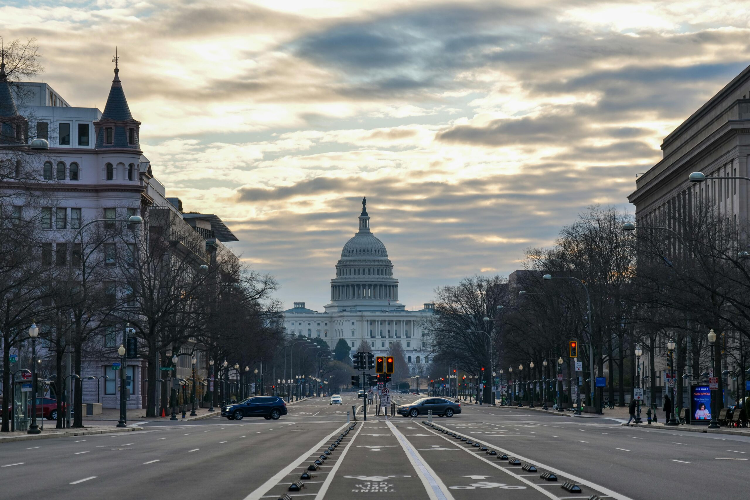 The US Capitol Building captured from a street view in Washington D.C. at sunrise.