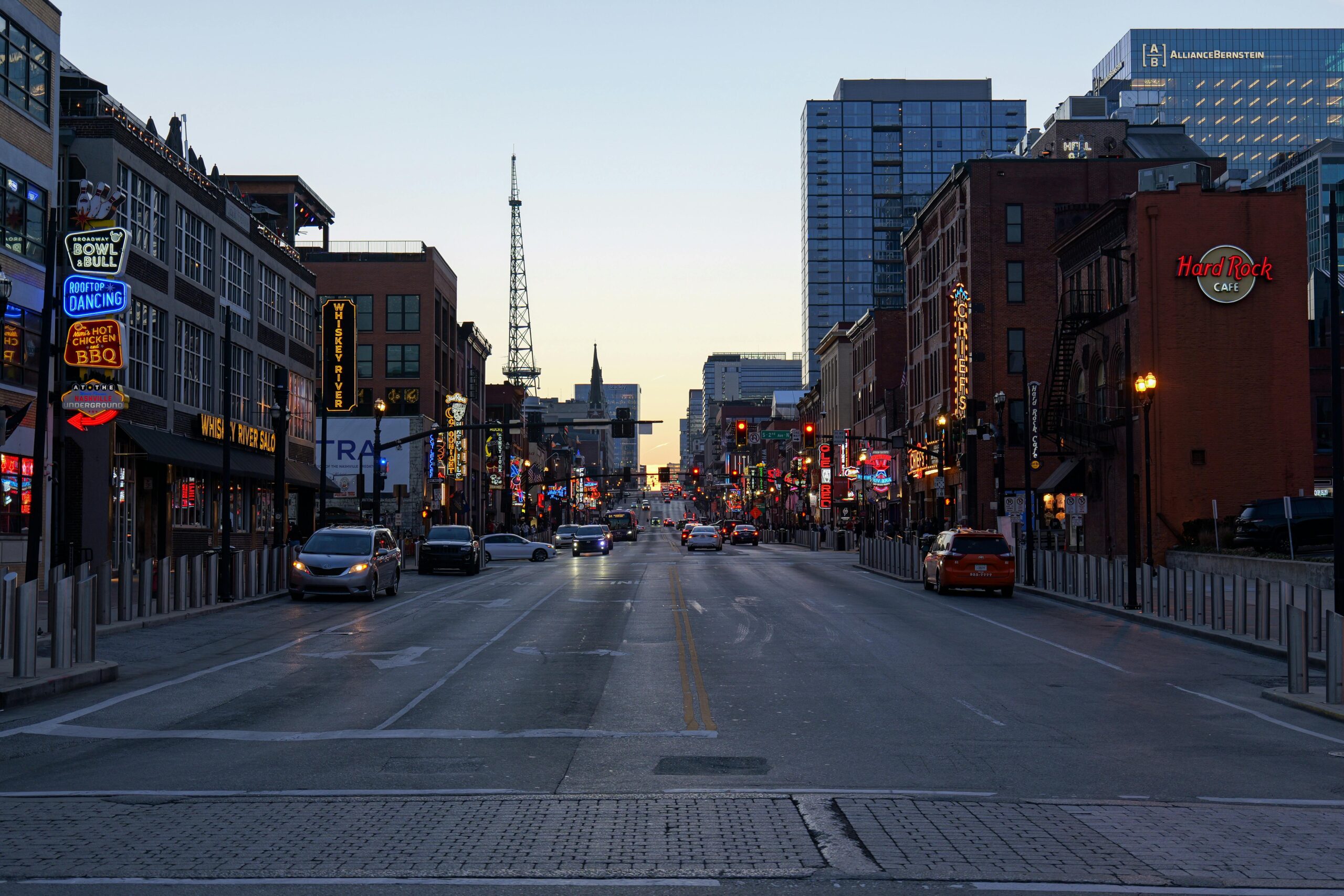 Discover the lively street scene in Nashville, Tennessee, with glowing signs and bustling city life.