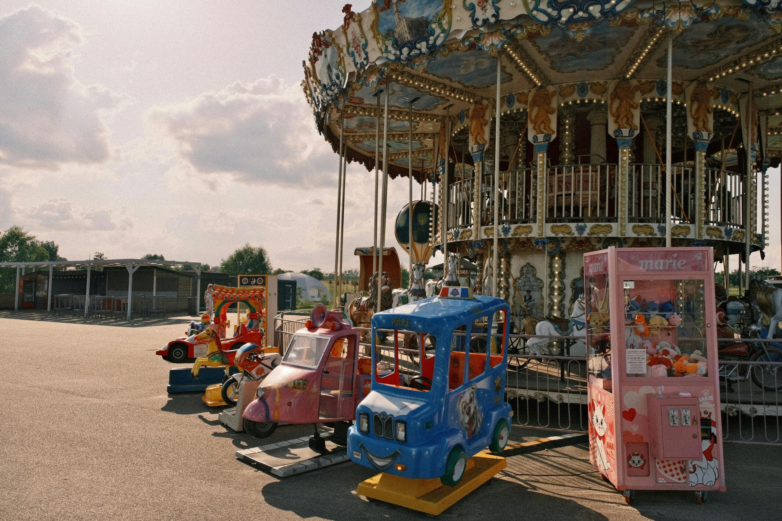 A nostalgic scene of an empty amusement park with a vintage carousel and colorful rides.