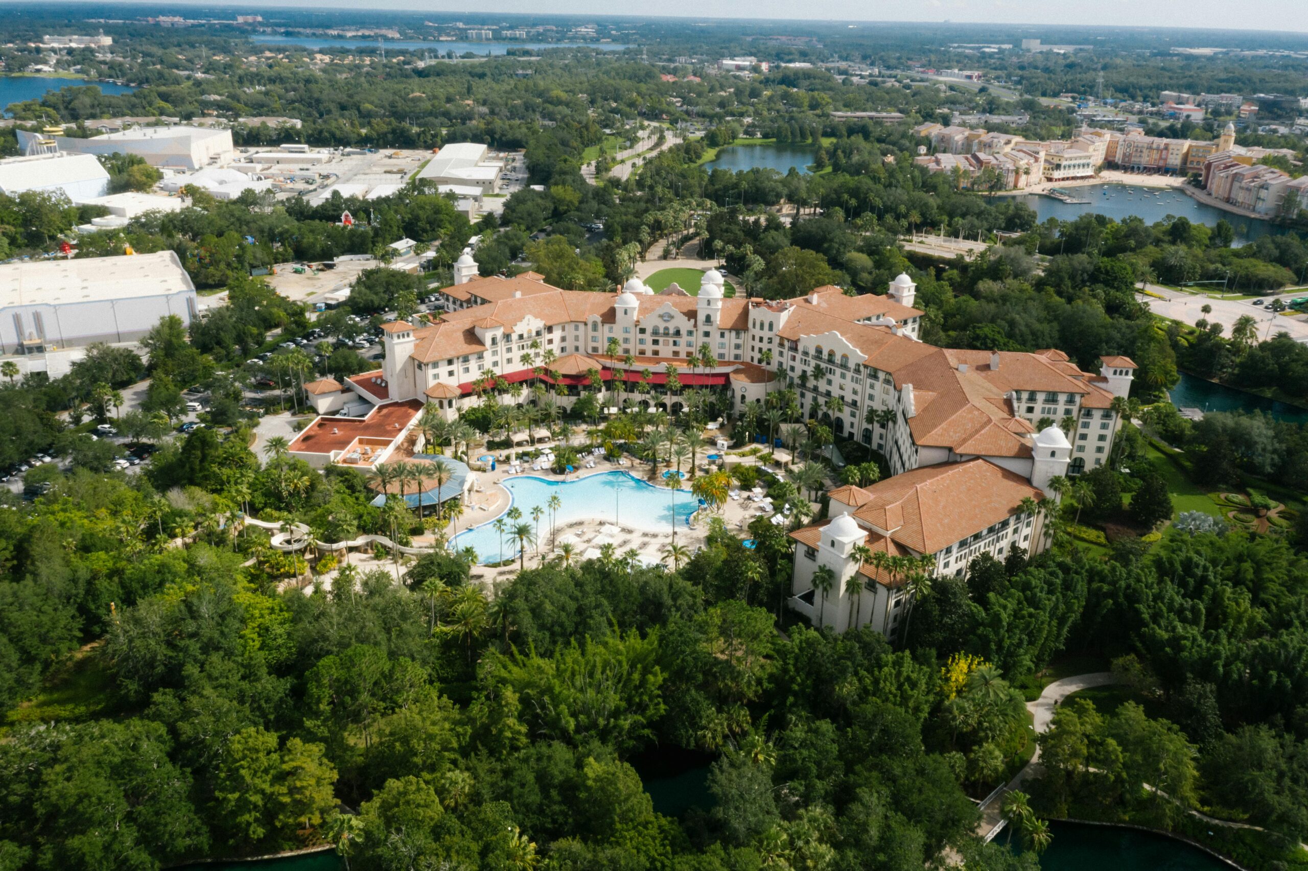Aerial view of a luxury hotel surrounded by lush greenery and a large pool in Orlando.