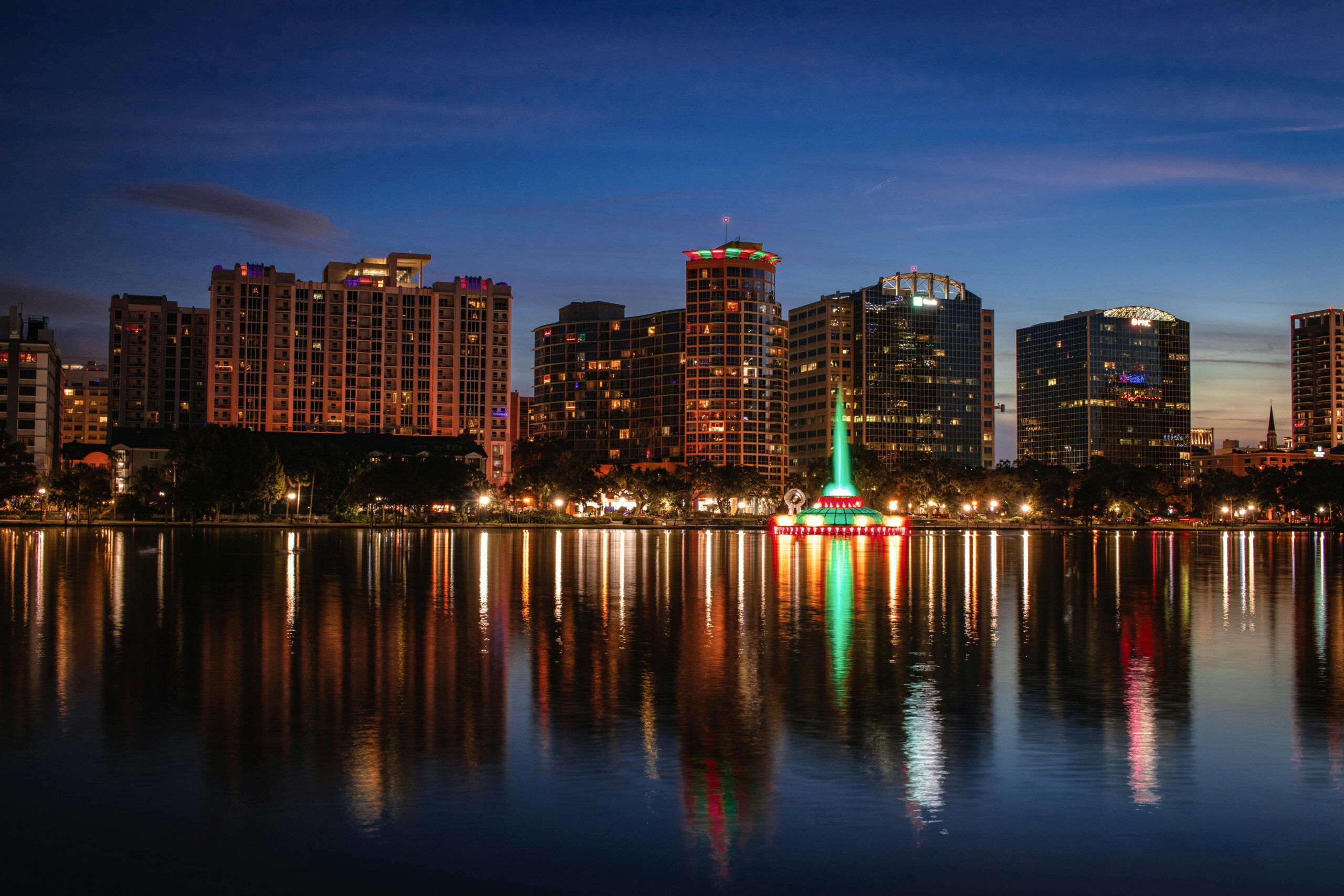 Beautiful view of Orlando skyline at dusk with reflections on Lake Eola.