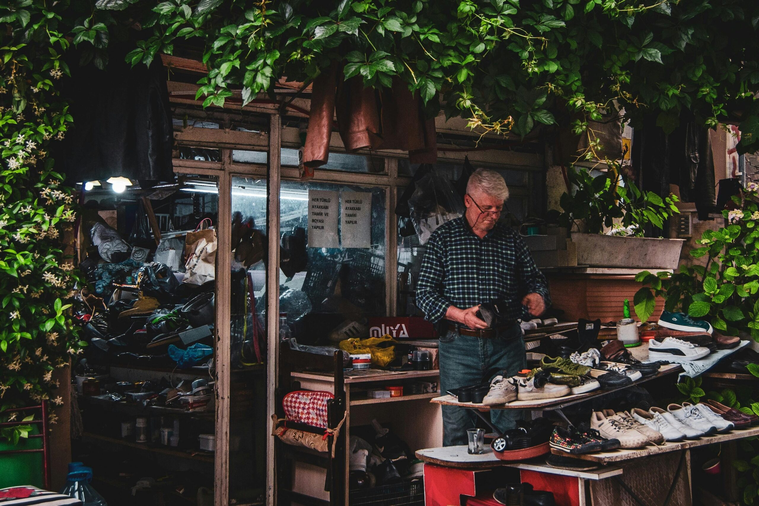Local artisan working amidst various shoes at a vibrant outdoor shop in Samsun.