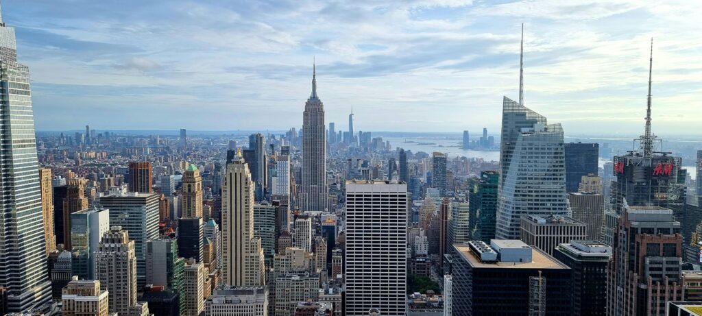 Aerial view of New York City skyline featuring iconic skyscrapers under a cloudy sky.
