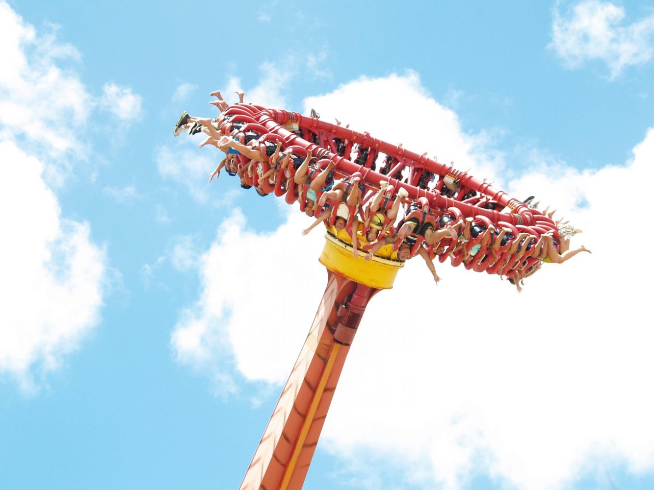Experience the thrill of an extreme amusement park ride against a clear blue sky