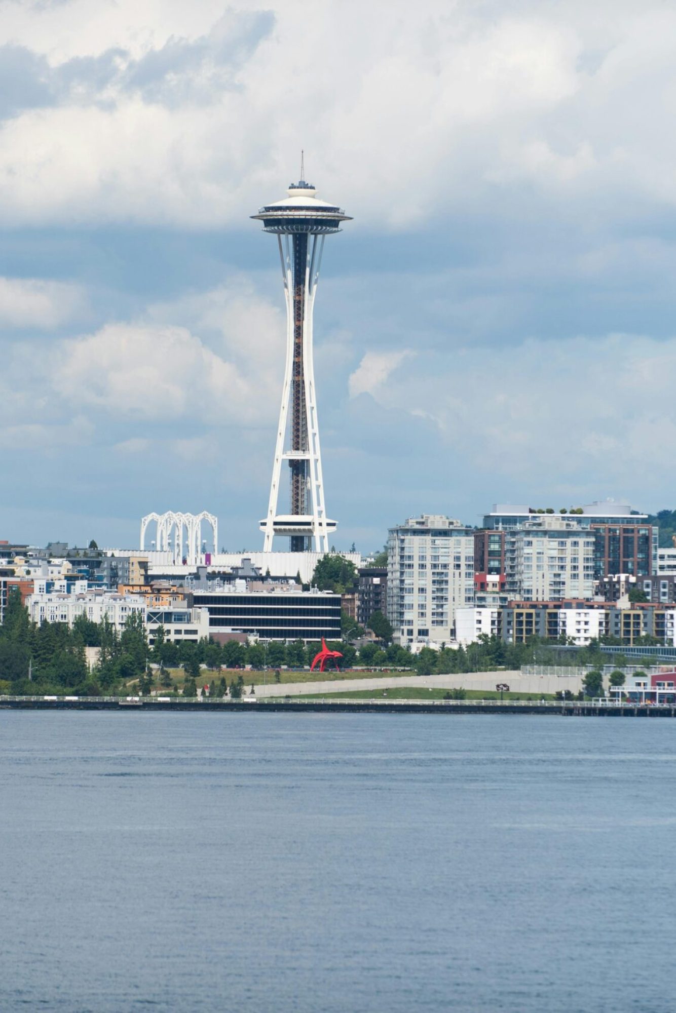 A scenic view of the Seattle skyline featuring the iconic Space Needle against a cloudy sky.