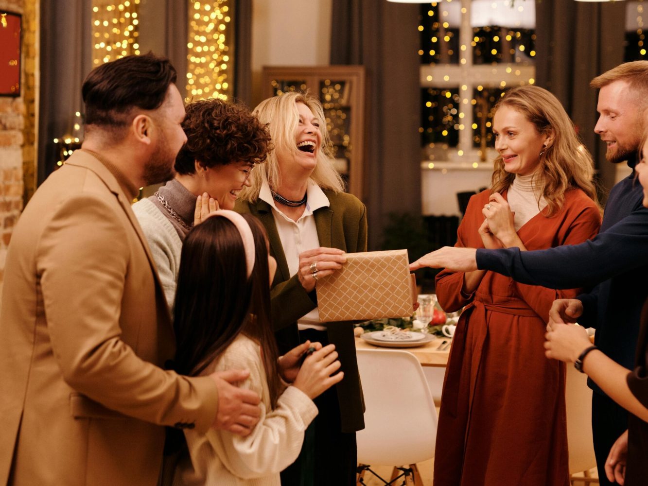 A cheerful group of friends celebrating together indoors during Christmas festivities.